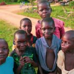 six children standing near rough road